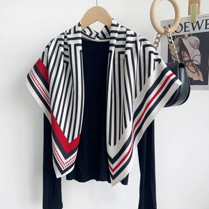 Détail d'un élégant foulard en soie à rayures noir et blanc avec motifs rouges et pois