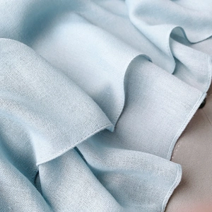 Macro shot of light blue cotton linen scarf showing soft texture and woven fabric detail