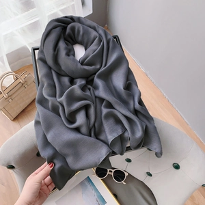 Close-up of a soft dark gray linen scarf elegantly draped over a chair for home decor