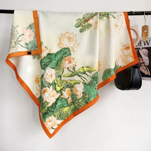 Detail of silk square scarf featuring lotus floral print and orange borders