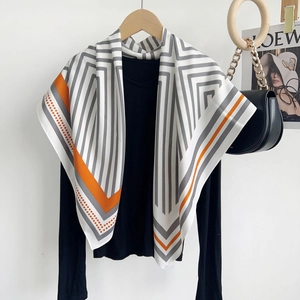 Élégant foulard carré blanc à rayures grises et bordure orange sur pull noir