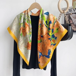 Close-up of printed silk-like scarf featuring vibrant floral patterns and yellow borders