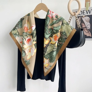 Detail of silk scarf with yellow floral patterns and dark brown borders on a black top