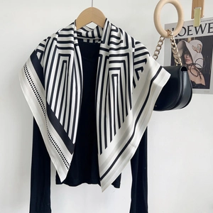 Écharpe élégante à rayures noires et blanches sur cintre avec décor minimaliste