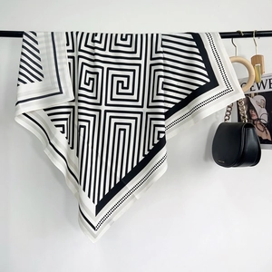 Détail d'un foulard à motif labyrinthe géométrique noir et blanc avec une texture soyeuse