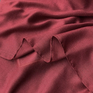 Close-up of dark red linen scarf fabric showing fine grain texture and soft drape