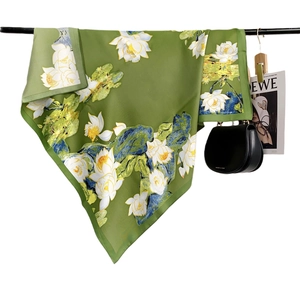 Green silk shawl with vintage lotus print and mountain elements on display stand