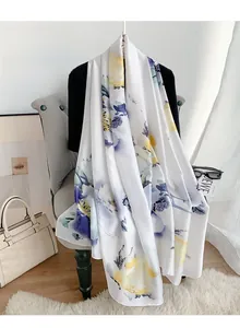 Dettaglio di sciarpa in seta con stampa floreale su poltrona ed accessori alla moda
