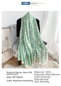 Detailed view of long green silk-like scarf with white tulip prints and satin texture
