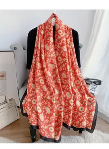 Exquisite silk satin scarf featuring elegant gold floral patterns and a black border detail
