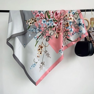 Close-up of elegant floral silk scarf with pink and grey tulip patterns on white