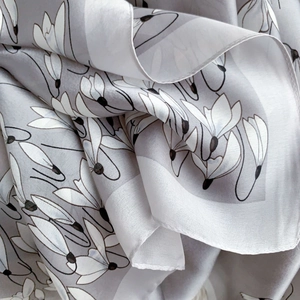 Close-up of lightweight light gray floral silk scarf with white magnolia patterns