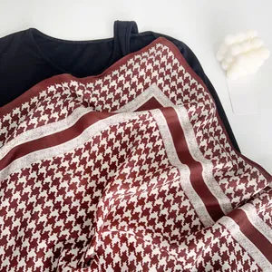 Close-up of classic brown and white houndstooth pattern on soft velvet scarf texture