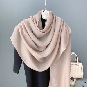 Detail of soft beige cotton linen shawl draped on mannequin with stylish accessories