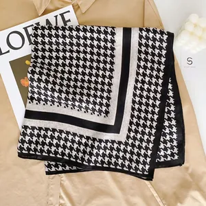 Detail of classic black and white houndstooth silk scarf with elegant contrast borders