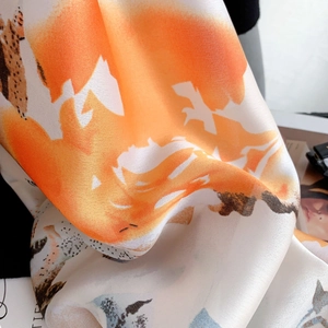 Dettaglio di una sciarpa di seta leggera con stampa a inchiostro e drappeggio elegante