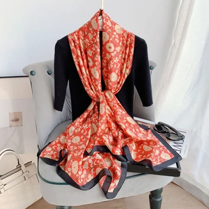 Detail of red floral silk shawl with golden patterns draped over a black top