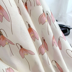 Detail of silk-like floral scarf fabric showing soft drape and pink bell flower print