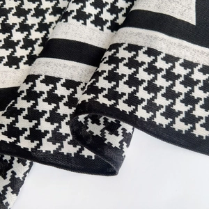 Detailed macro view of black and white houndstooth wool-touch fabric and woven texture