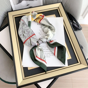 Elegant leaf print silk scarf with floral pattern and golden frame display