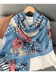 Detail of floral linen blend scarf hanging on a wooden hanger with blue houndstooth pattern