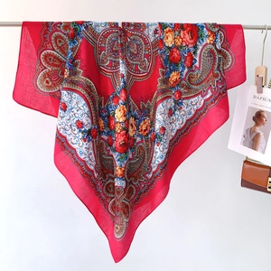 Close-up of ethnic floral paisley patterns on a large red square scarf and shawl