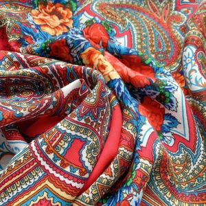 Close-up detail of paisley printed silk scarf with vibrant ethnic floral patterns