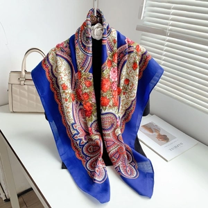 Detail of navy paisley square scarf with red roses and silky texture on a display stand