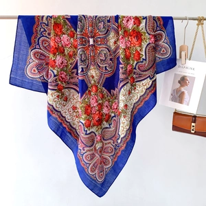 Close-up of royal blue ethnic scarf featuring red roses and paisley patterns on soft fabric