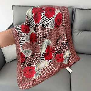 Detailed close-up of floral print scarf with elegant rose patterns on a leather sofa