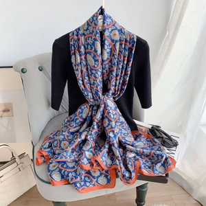 Detail of elegant blue floral silk scarf with orange edges on a chair for lifestyle look