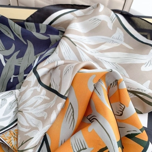 Close-up of elegant floral print silk scarf showing smooth texture and drape quality