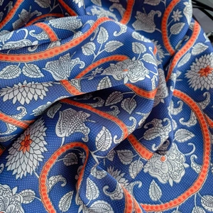 Detailed macro view of soft royal blue floral silk fabric with elegant pattern draping