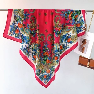 Detail of red ethnic scarf with paisley floral patterns and silky texture on display