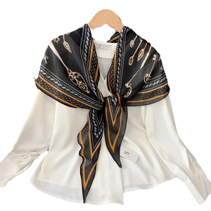 Elegant cashew green rhombic silk scarf paired with a white long-sleeve satin shirt