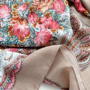 Macro detail of bohemian paisley and red rose floral print on camel colored silk scarf