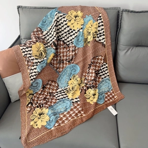 Detail of elegant floral scarf draped on sofa showing soft texture and paisley print