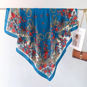 Close-up of ethnic style blue silk scarf featuring paisley and red rose floral patterns