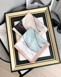 Dettaglio ravvicinato di un foulard in seta con motivi astratti e bordi rifiniti