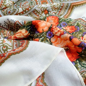 Detailed close-up showing vibrant floral patterns and paisley borders on thin silk fabric