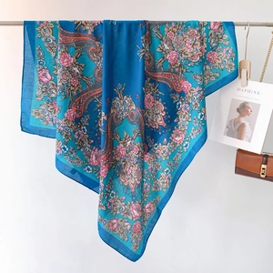 Dettaglio della sciarpa blu con motivo paisley ed elegante consistenza effetto velluto