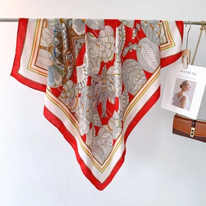 Close-up of red and cream silk scarf with bird pattern and hand-rolled edges