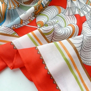 Detailed macro view showing red and green luxury pattern on twill weave silk scarf texture