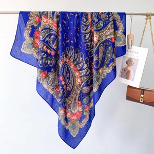 Detail of blue ethnic paisley scarf with red roses showing soft texture and drapes