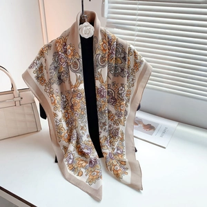 Vista dettagliata di sciarpa beige a fiori paisley con morbida consistenza di seta