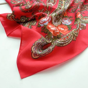 Macro detail of red paisley scarf showing herringbone texture and refined edge stitching