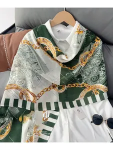 Detail of cotton linen scarf with green block patchwork and gold chain print pattern