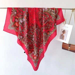 Detail of red paisley large square scarf featuring vintage floral patterns and silk texture