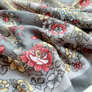 Dettaglio dello scialle etnico grigio con rose e motivi paisley su morbido tessuto twill