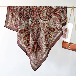 Detailed macro view of the paisley and floral pattern on the large brown shawl scarf